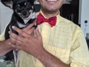 Cute dog held by man in a bow tie