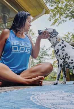 Woman and dog bonding with yoga mat